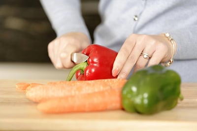 Beautiful young woman preparing the ingredients for a meal in her kitchen.