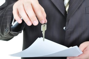 One businessman hand and the key, paper agreement