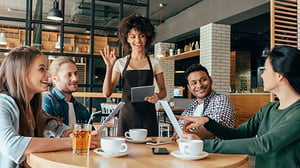 A waitress takes a table's orders at a trendy restaurant