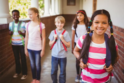 Portrait of smiling little school kids in school corridor