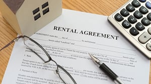 A rental agreement sits on a desk ready to be signed