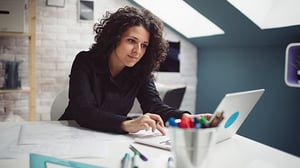 A woman works diligently on her laptop