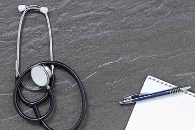 Still life of doctors medical stethoscope on a stone surface